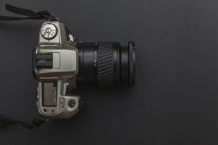 Photographer workplace with dslr camera system on dark black table background. Hobby travel...