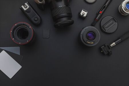 Photographer workplace with dslr camera system, camera cleaning kit, lens and camera accessory on dark black table background. Hobby travel photography concept. Flat lay top view copy spaceの写真素材