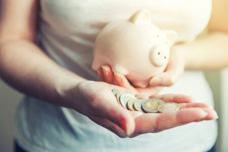 Female woman hands holding pink piggy bank and euro coins. Saving investment budget business wealth retirement financial money banking conceptの写真素材