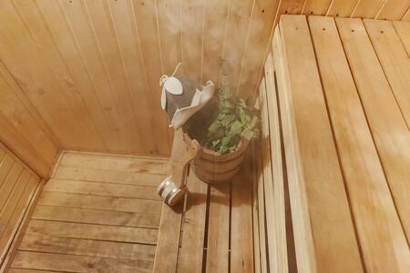 Interior details Finnish sauna steam room with traditional sauna accessories basin birch broom scoop...