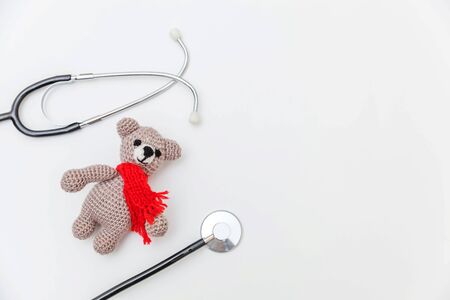 Simply minimal design toy bear and medicine equipment stethoscope isolated on white background. Health care children doctor concept. Pediatrician symbol. Flat lay top view copy spaceの写真素材