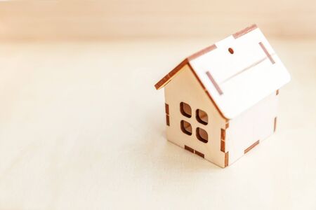 Miniature toy model house on wooden backdrop. Eco Village, abstract environmental background. Real...