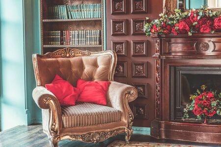 Luxury classic interior of home library. Sitting room with bookshelf, books, arm chair, sofa and fireplace. Clean and modern decoration with elegant furniture. Education read study wisdom conceptの写真素材