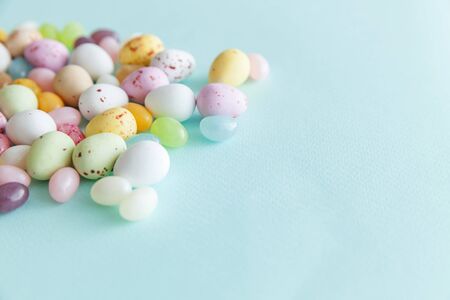 Happy Easter concept. Preparation for holiday. Easter candy chocolate eggs and jellybean sweets isolated on trendy pastel blue background. Simple minimalism flat lay top view copy spaceの写真素材