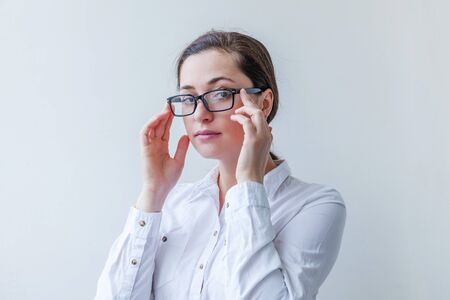 Beautiful happy girl smiling. Beauty simple portrait young smiling brunette woman in eyeglasses isolated on white background. Positive human emotion facial expression body language. Copy space.の写真素材