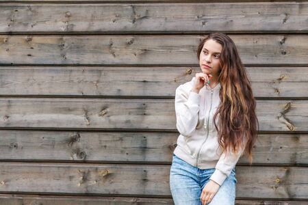 Happy girl smiling. Beauty portrait young happy positive laughing brunette woman on wooden wall...