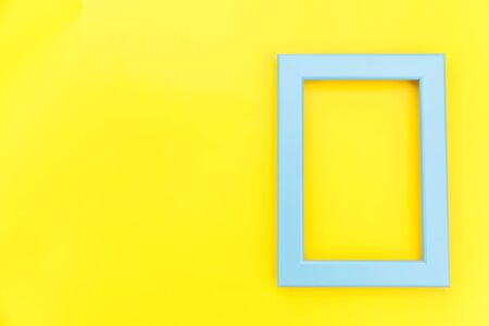 Simply design with empty blue frame isolated on yellow colourful trendy background. Top view, flat lay, copy space, mock up. Minimal conceptの写真素材