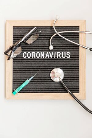 Text phrase Coronavirus syringe and stethoscope on black letter board background. Novel coronavirus 2019-nCoV, MERS-Cov middle East respiratory syndrome coronavirus originatingの写真素材