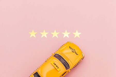Yellow toy car Taxi Cab and 5 stars rating isolated on pink background. Smartphone application of...