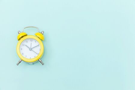 Ringing twin bell vintage classic alarm clock Isolated on blue colourful trendy pastel background....