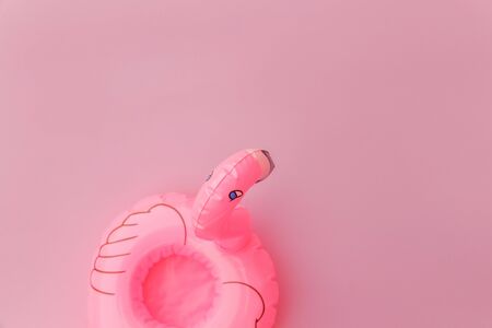 Summer beach composition. Simply minimal design with Inflatable flamingo isolated on pastel pink background. Pool float party, trendy celebrity fashion concept. Flat lay top view copy spaceの写真素材