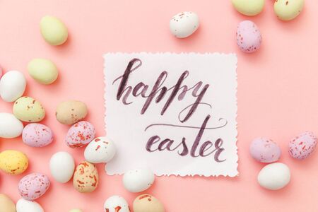 Happy Easter concept. Inscription HAPPY EASTER letters candy chocolate eggs and jellybean sweets...