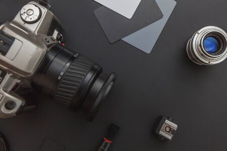 Photographer workplace with dslr camera system, camera cleaning kit, lens and camera accessory on...