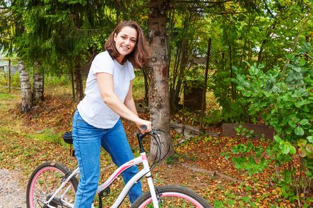 Young woman riding bicycle in summer city park outdoors. Active people. Hipster girl relax and rider...