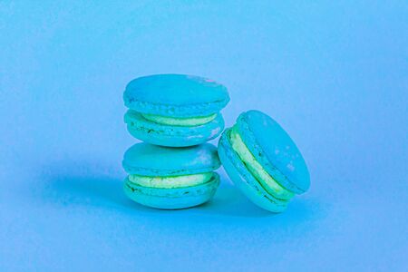 Sweet almond colorful unicorn blue macaron or macaroon dessert cake isolated on trendy blue pastel background. French sweet cookie. Minimal food bakery concept. Copy spaceの写真素材