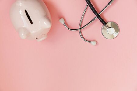 Medicine doctor equipment stethoscope and piggy bank isolated on pink pastel background. Health care...