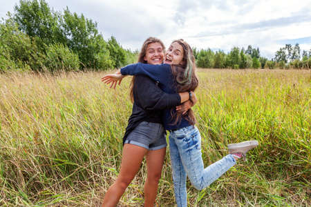 Summer holidays vacation happy people concept. Group of two girl friends sisters dancing hugging and...
