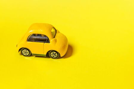 Simply design yellow vintage retro toy car isolated on yellow colorful background. Automobile and transportation symbol. City traffic delivery concept. Copy spaceの写真素材