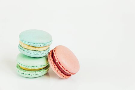 Sweet almond colorful pastel pink blue green macaron or macaroon dessert cake isolated on white background. French sweet cookie. Minimal food bakery concept. Copy spaceの写真素材