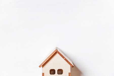 Simply minimal design with miniature toy house isolated on white background. Mortgage property insurance dream home concept. Flat lay top view copy spaceの写真素材