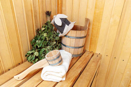 Interior details Finnish sauna steam room with traditional sauna accessories basin birch broom scoop felt hat towel. Traditional old Russian bathhouse SPA Concept. Relax country village bath conceptの写真素材