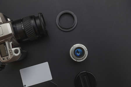 Photographer workplace with dslr camera system, camera cleaning kit, lens and camera accessory on...