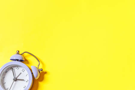Simply minimal design ringing twin bell vintage classic alarm clock Isolated on yellow background. Rest hours time of life good morning night wake up awake concept. Flat lay top view copy spaceの写真素材