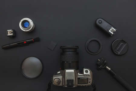 Photographer workplace with dslr camera system, camera cleaning kit, lens and camera accessory on dark black table background. Hobby travel photography concept. Flat lay top view copy spaceの写真素材