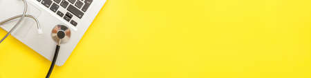 Stethoscope keyboard laptop computer isolated on yellow background. Modern medical Information...