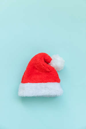 Simply minimal design Christmas Santa Claus hat isolated on blue pastel colorful trendy background. Christmas New Year december time for celebration concept. Flat lay top view copy spaceの写真素材
