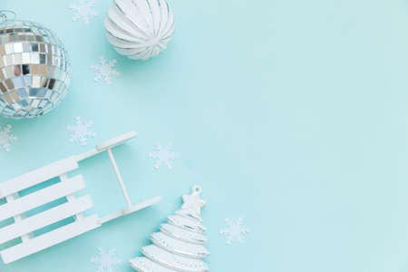 Simply minimal composition winter objects ornament sled fir tree ball isolated on blue pastel trendy background. Christmas New Year december time for celebration concept. Flat lay top view copy spaceの写真素材