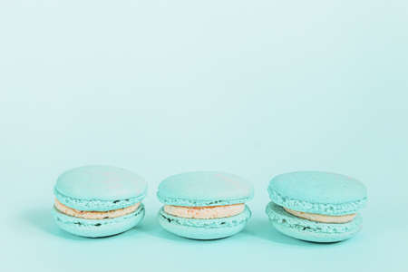 Sweet almond colorful unicorn blue macaron or macaroon dessert cake isolated on trendy blue pastel background. French sweet cookie. Minimal food bakery concept. Copy spaceの写真素材