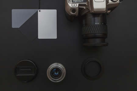 Photographer workplace with dslr camera system, camera cleaning kit, lens and camera accessory on dark black table background. Hobby travel photography concept. Flat lay top view copy spaceの写真素材