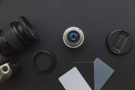 Photographer workplace with dslr camera system, camera cleaning kit, lens and camera accessory on dark black table background. Hobby travel photography concept. Flat lay top view copy spaceの写真素材