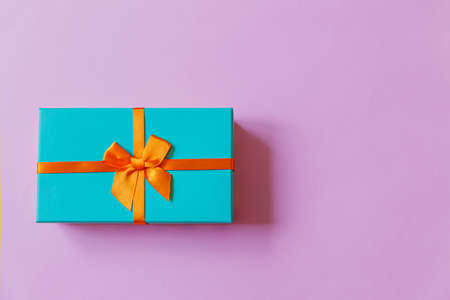 Christmas New Year birthday valentine celebration present romantic concept. Simply minimal design blue gift box isolated on violet purple colorful background. Flat lay top view copy spaceの写真素材