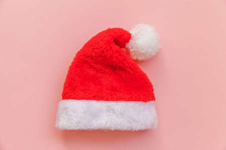 Simply minimal design Christmas Santa Claus hat isolated on pink pastel colorful trendy background. Christmas New Year december time for celebration concept. Flat lay top view copy spaceの写真素材