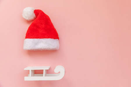Simply minimal composition Christmas Santa Claus hat sled isolated on pink pastel colorful trendy...