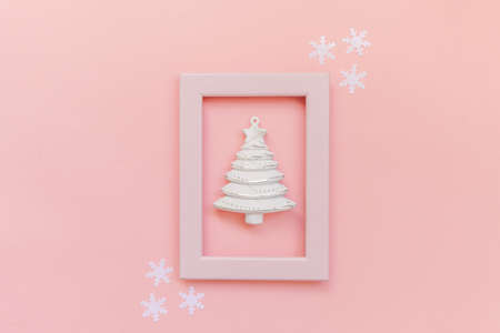 Simply minimal composition winter objects ornament fir tree in pink frame isolated on pink pastel...