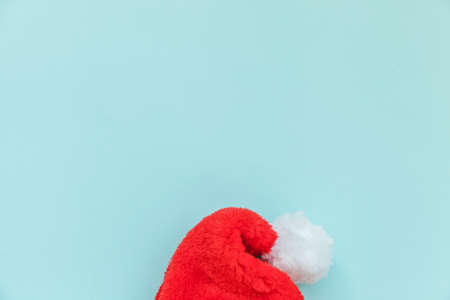Simply minimal design Christmas Santa Claus hat isolated on blue pastel colorful trendy background. Christmas New Year december time for celebration concept. Flat lay top view copy spaceの写真素材