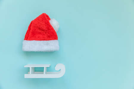 Simply minimal composition Christmas Santa Claus hat sled isolated on blue pastel colorful trendy...