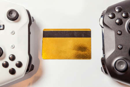 White black two joystick gamepad game console golden credit card isolated on white background. Computer gaming technology play competition videogame control confrontation concept. Cyberspace symbolの写真素材