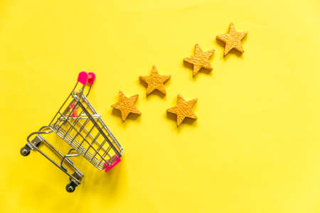 Simply flat lay design small supermarket grocery push cart for shopping with wheels and 5 gold stars...