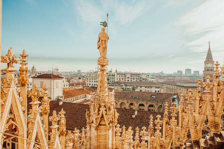 Roof of Milan Cathedral Duomo di Milano with Gothic spires and white marble statues. Top tourist attraction on piazza in Milan, Lombardia, Italy. Wide angle view of old Gothic architecture and artの写真素材