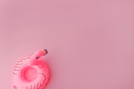 Summer beach composition. Simply minimal design with Inflatable flamingo isolated on pastel pink...