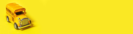 Simply design yellow classic toy car school bus isolated on yellow colorful background. Safety daily...