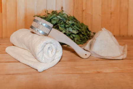Traditional old Russian bathhouse SPA Concept. Interior details Finnish sauna steam room with traditional sauna accessories set towel birch broom scoop felt. Relax country village bath concept.の写真素材
