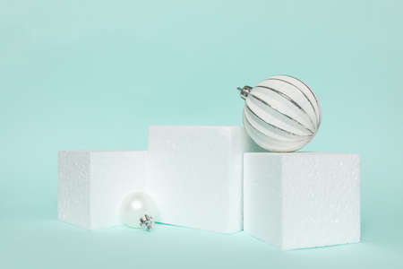 Simply minimal composition winter objects ornament and cube shapes geometric form podium isolated blue pastel background. Christmas New Year december time for celebration concept. Mockup copy spaceの写真素材