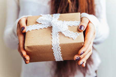 Simply design female woman hand holding vintage brown gift box isolated on white background. Christmas New Year birthday valentine celebration present romantic concept.の写真素材