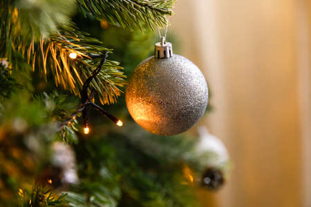 Classic Christmas decorated New year tree. Christmas tree with wite and silver decorations, ornaments toy and ball. Modern classical style interior design apartment. Christmas eve at homeの写真素材