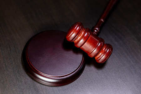 law theme. Court of law trial in session. Judge gavel on wooden table in lawyer office or court session. Mallet of judge on dark background. Justice human rights concept flat lay top viewの写真素材